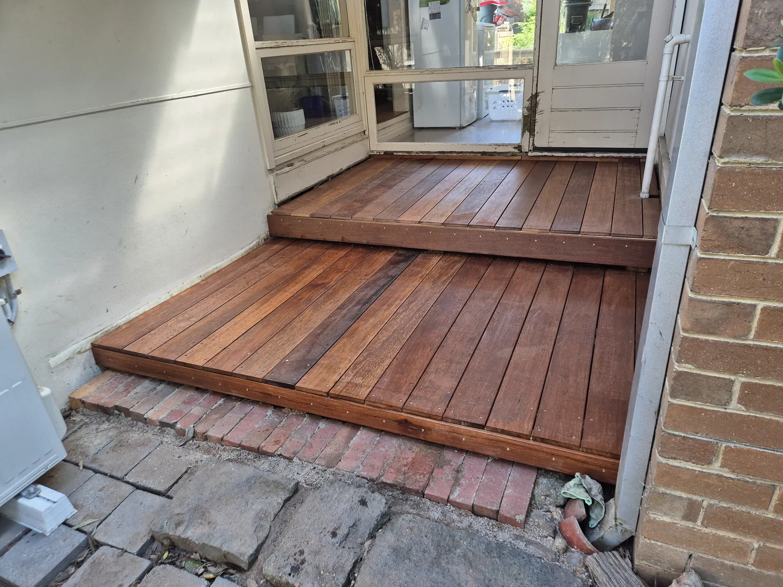 Finished two-tier hardwood deck and step at back door