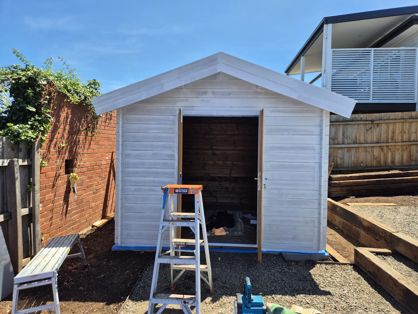 Cabin in white undercoat, doors and windows masked up ready for top-coat