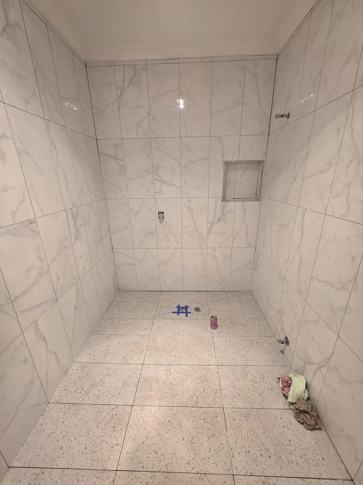 Tiled marble shower stall with built-in niche, ready for tapware and screen